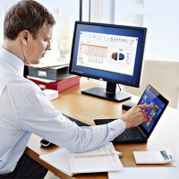 Man at Desk with Latitude 12 Touch 7000 Series and U2412M Monito