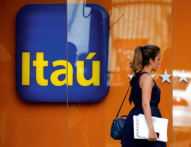 A woman walks past an Itau branch office in Rio de Janeiro